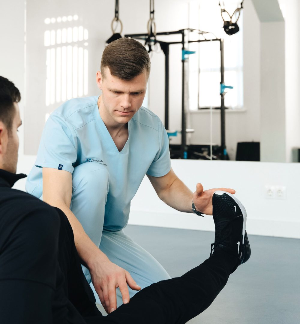 Physiotherapist guiding a patient through a leg exercise